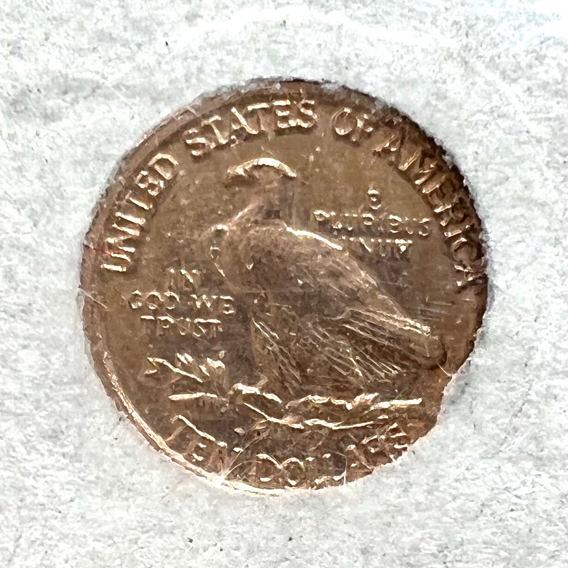 A 14 karat gold miniature commemorative of a 1933 Indian Head Gold Eagle coin.