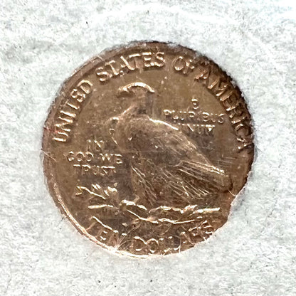 A 14 karat gold miniature commemorative of a 1933 Indian Head Gold Eagle coin.