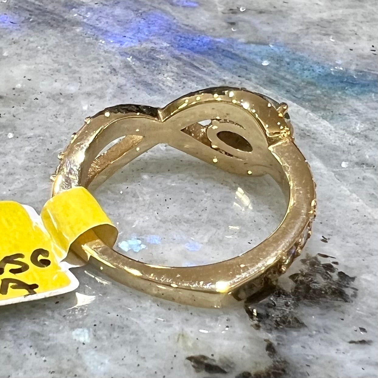 Yellow gold alexandrite and pave set diamond ring resting on labradorite tile.