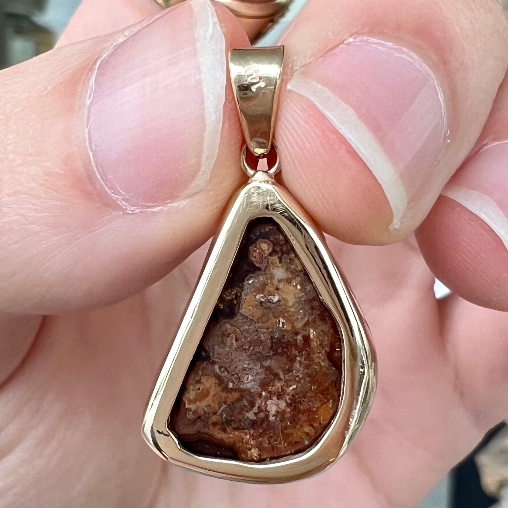 A handmade yellow gold solitaire pendant set with a green fire agate stone from Mexico.