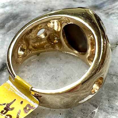 Men's rainbow fire agate ring set in yellow gold with champagne diamonds.  The ring style has holes.