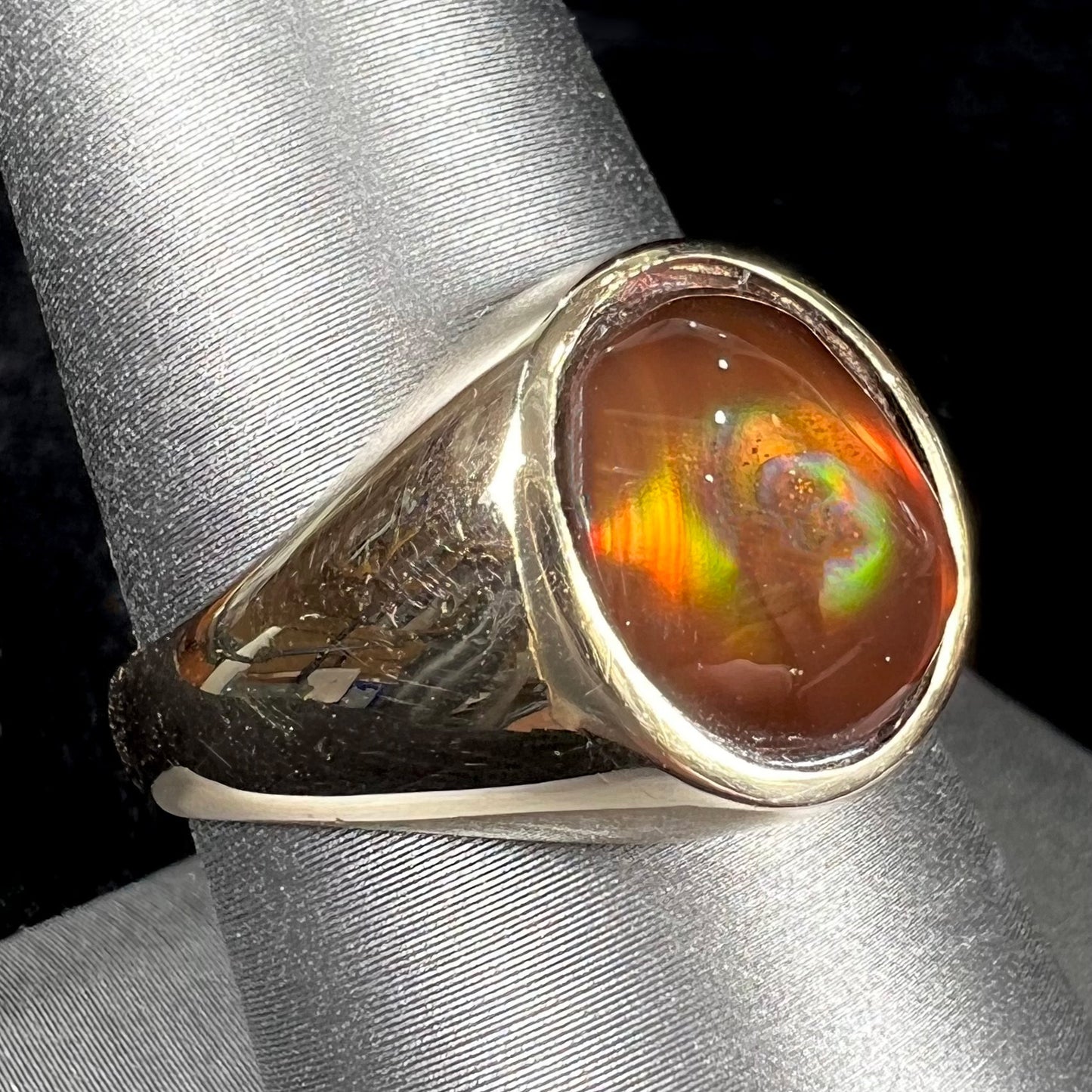 A unisex yellow gold flush set fire agate solitaire ring.