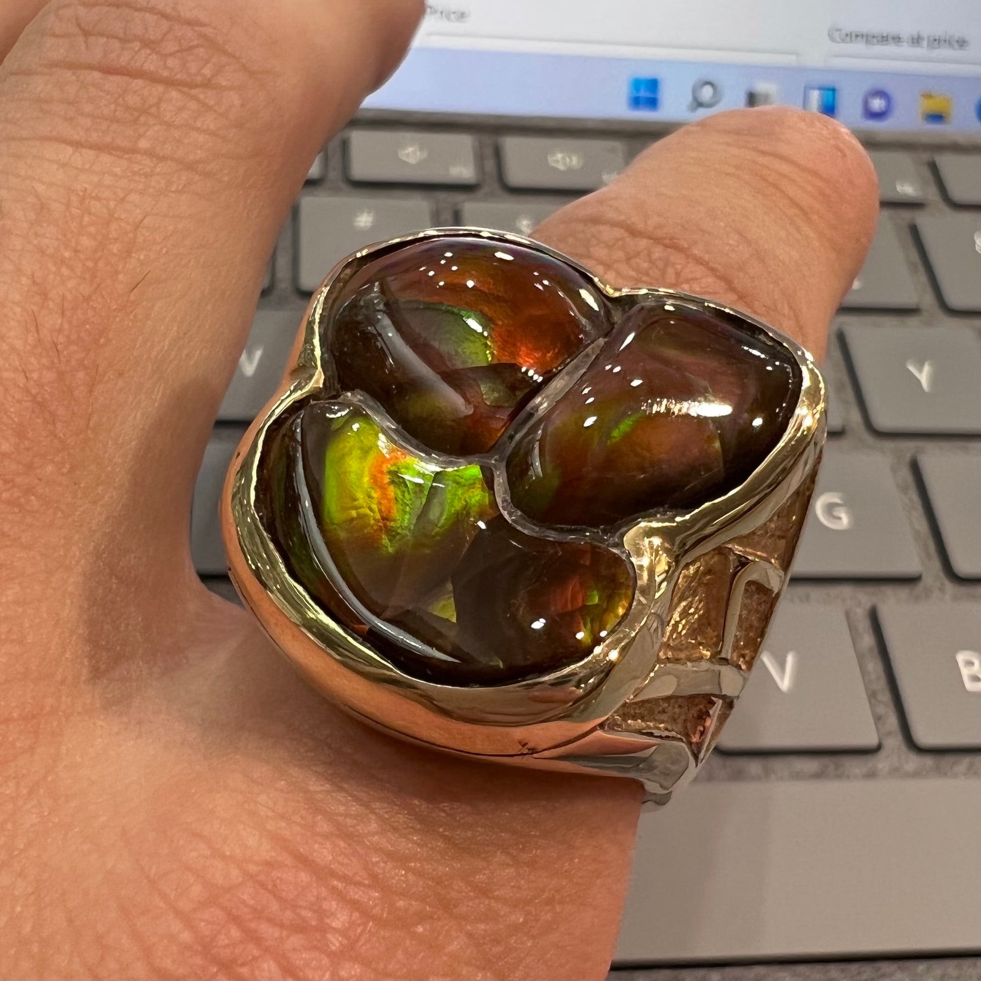 A men's yellow gold ring inlaid with three freeform cut fire agate stones.