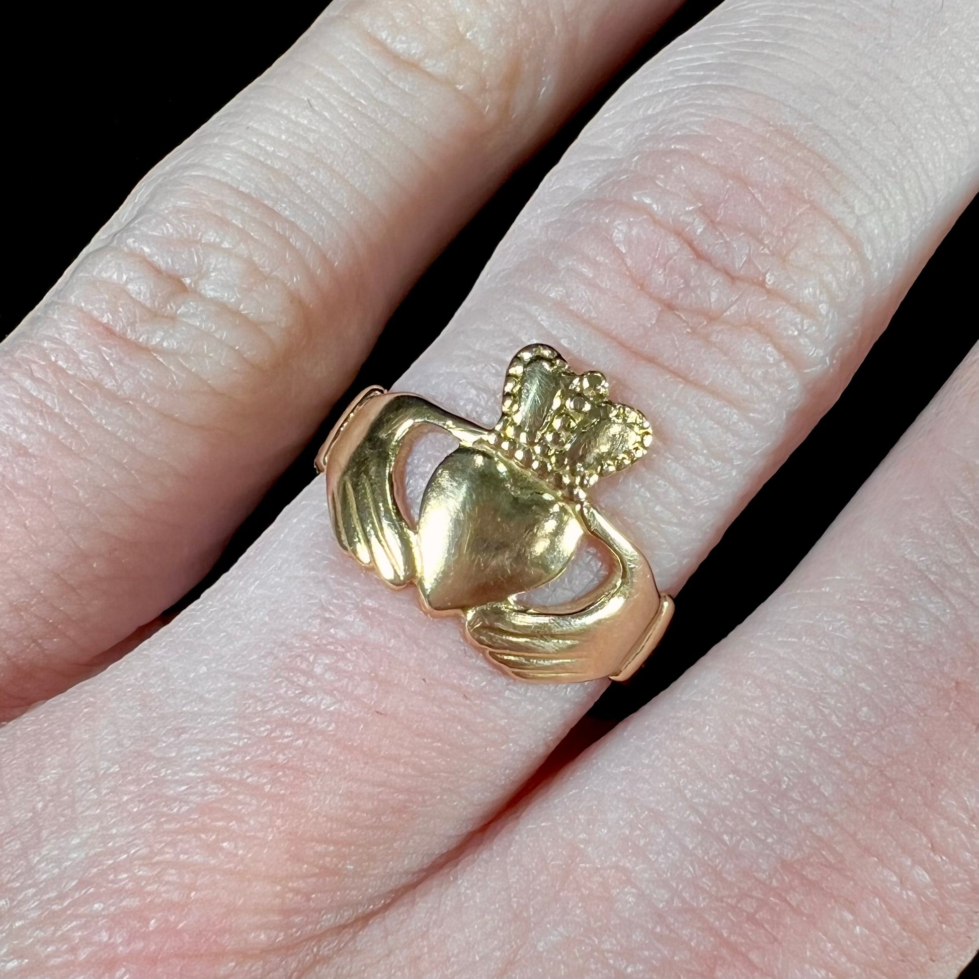 A ladies' 14 karat yellow gold Irish claddagh ring stamped with the maker's hallmarks.