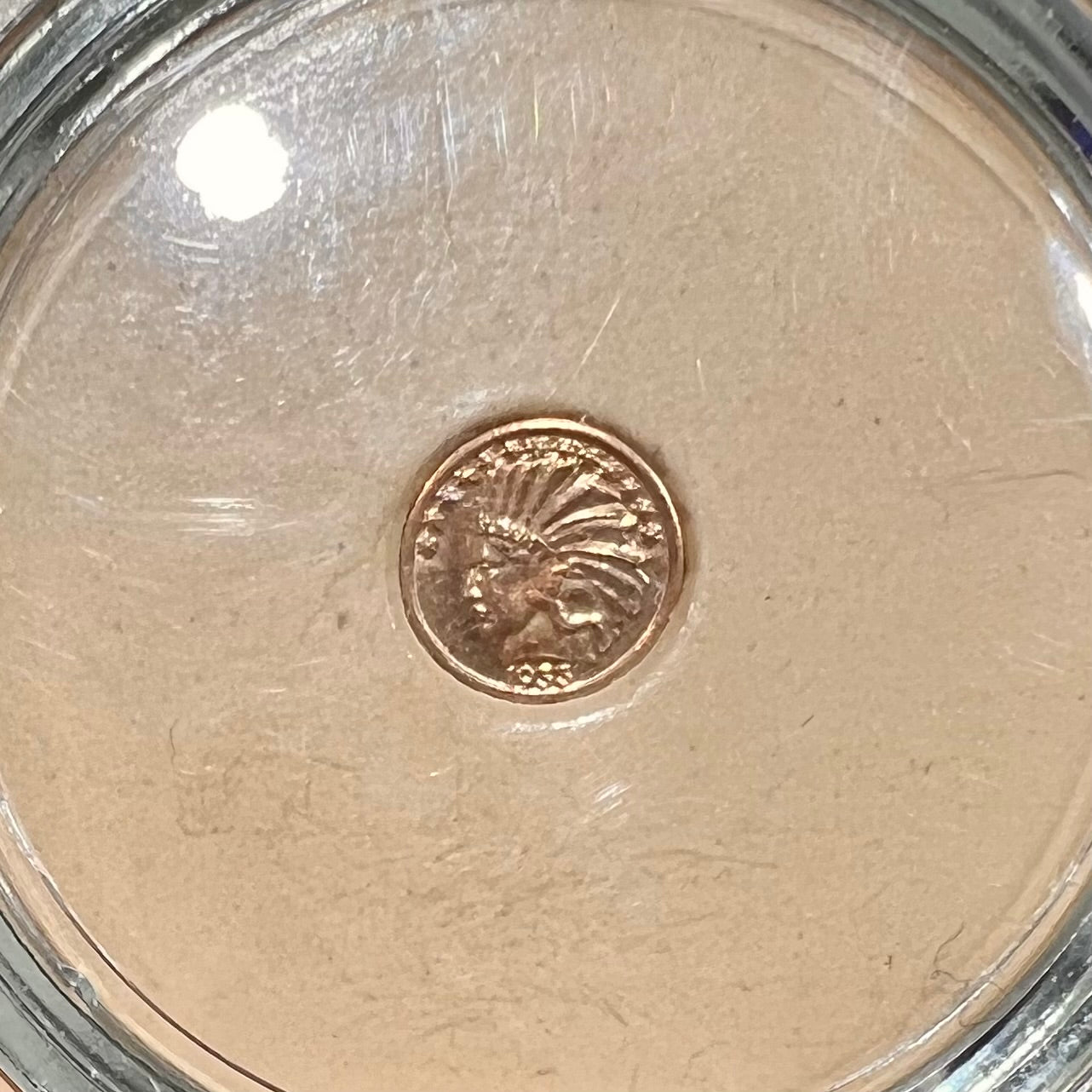 A 14 karat gold miniature commemorative of a 1933 Indian Head Gold Eagle coin.