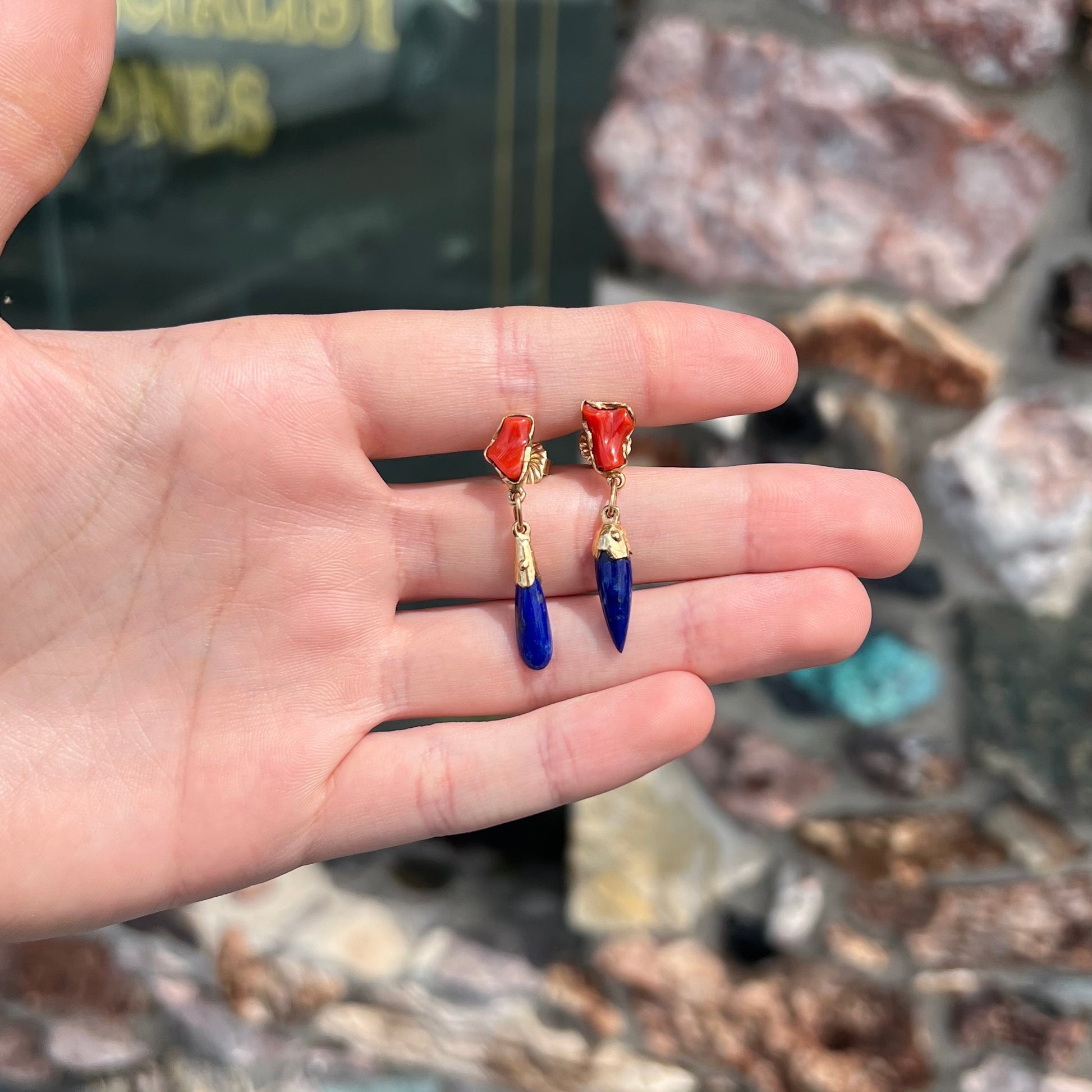 A pair of Navajo-handmade yellow gold dangle earrings set with lapis lazuli and polished coral branches.