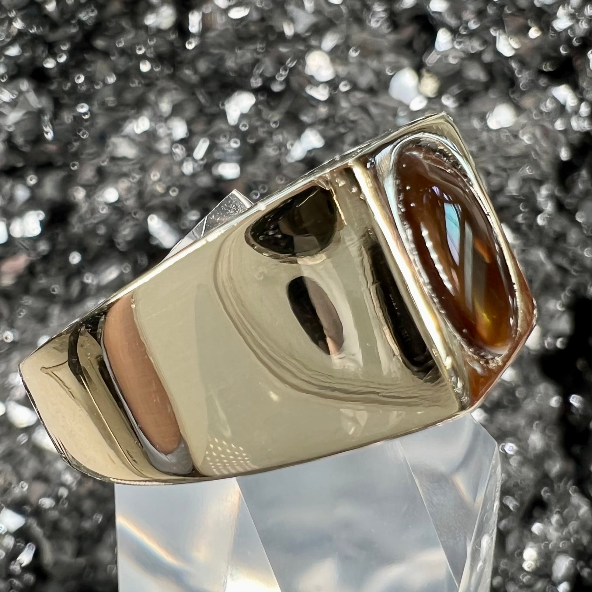 A men's yellow gold flush set fire agate solitaire ring.  The fire agate displays flashes of green, orange, and yellow.