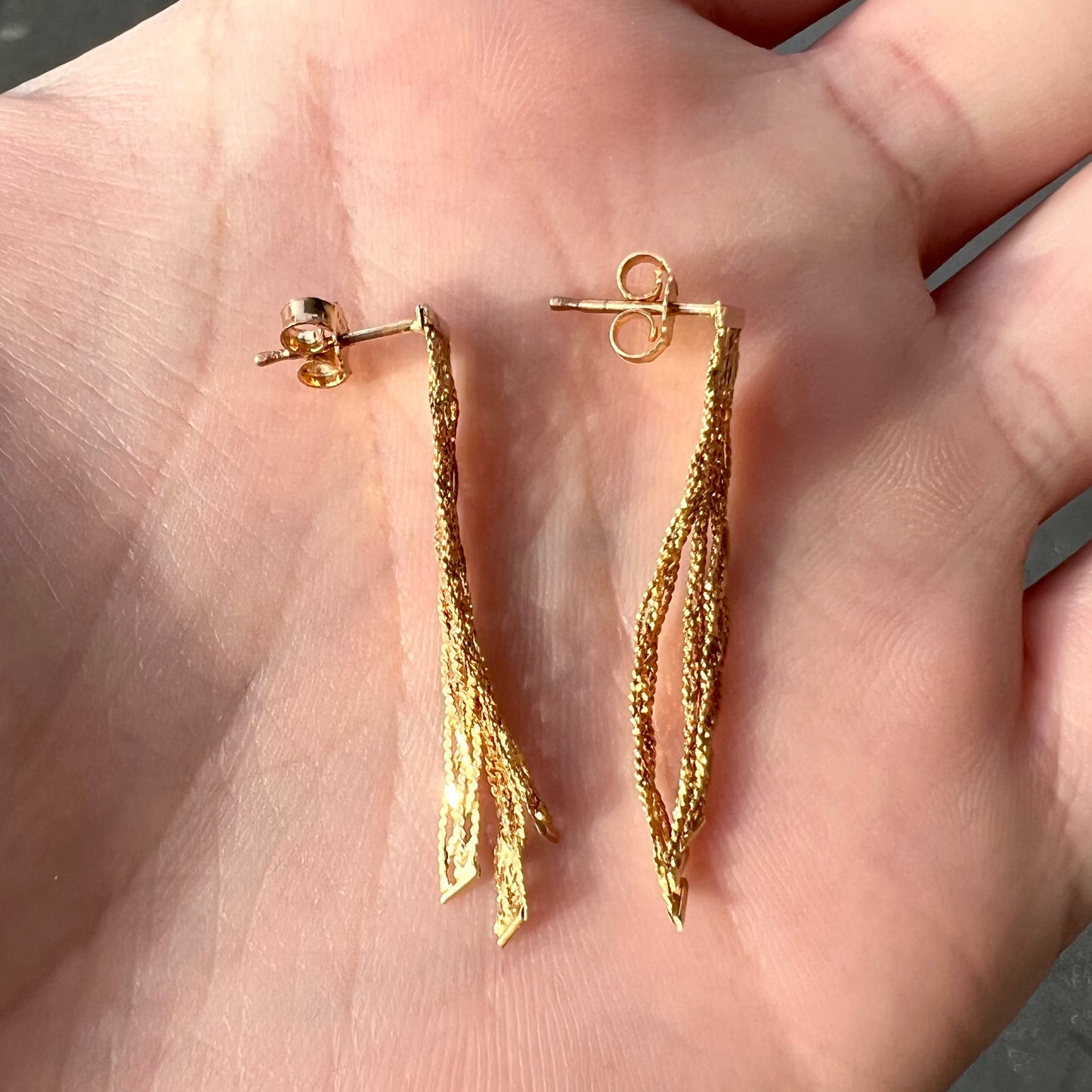 A pair of yellow gold waterfall dangle earrings.