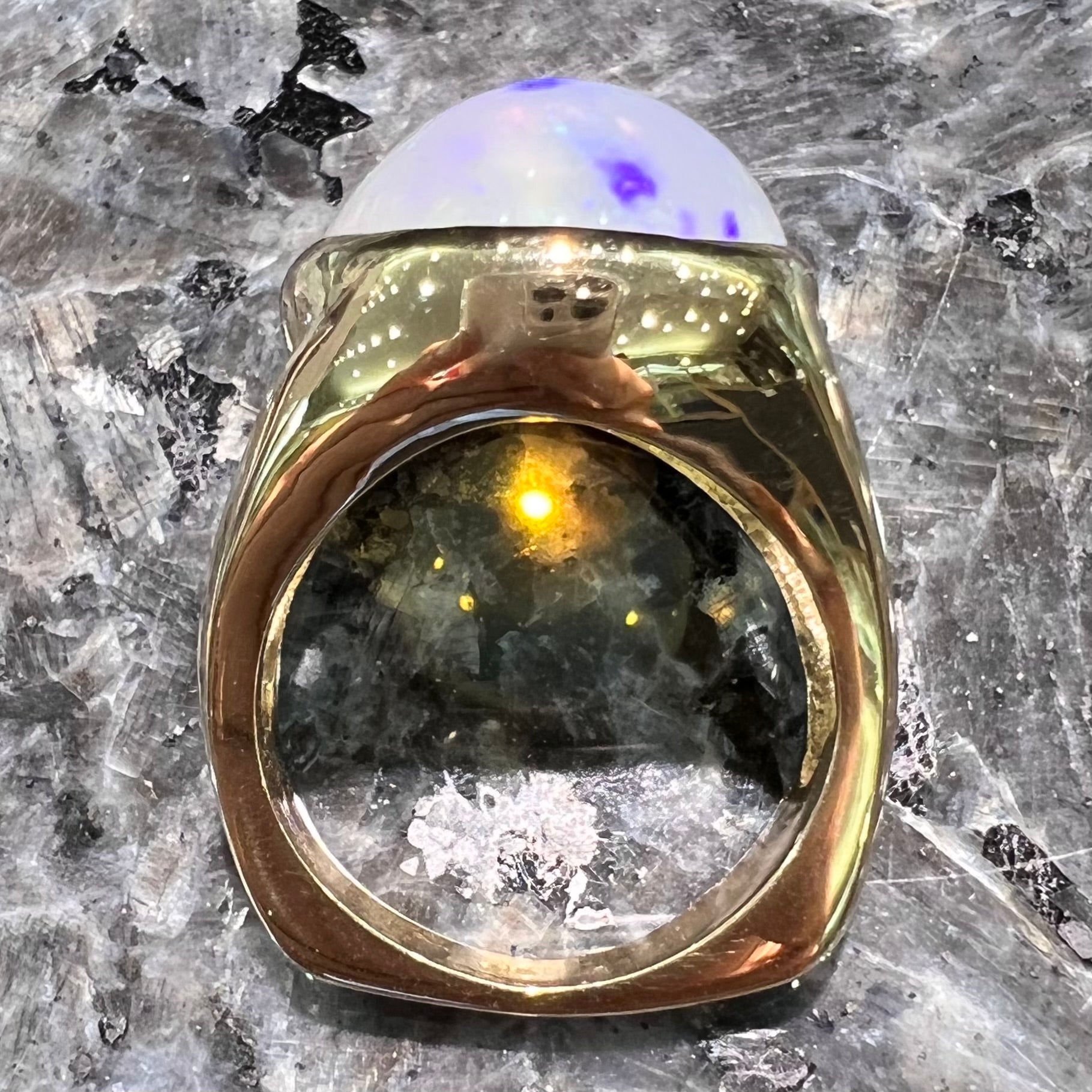A gold split shank solitaire ring set with an oval cabochon cut 16.83 carat Ethiopian jelly fire opal.