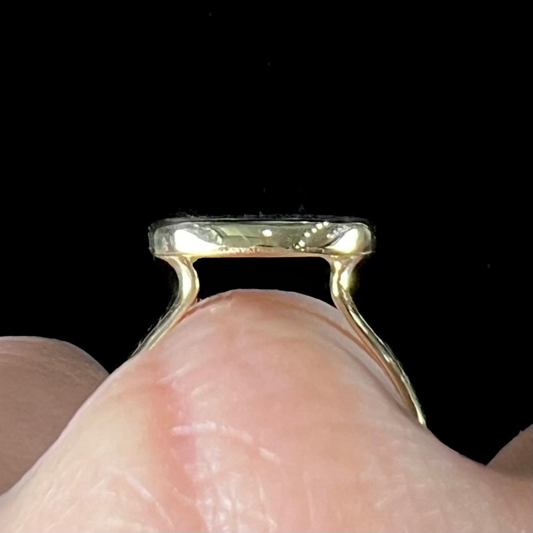 A ladies' yellow gold black opal solitaire ring from Lightning Ridge, Australia.
