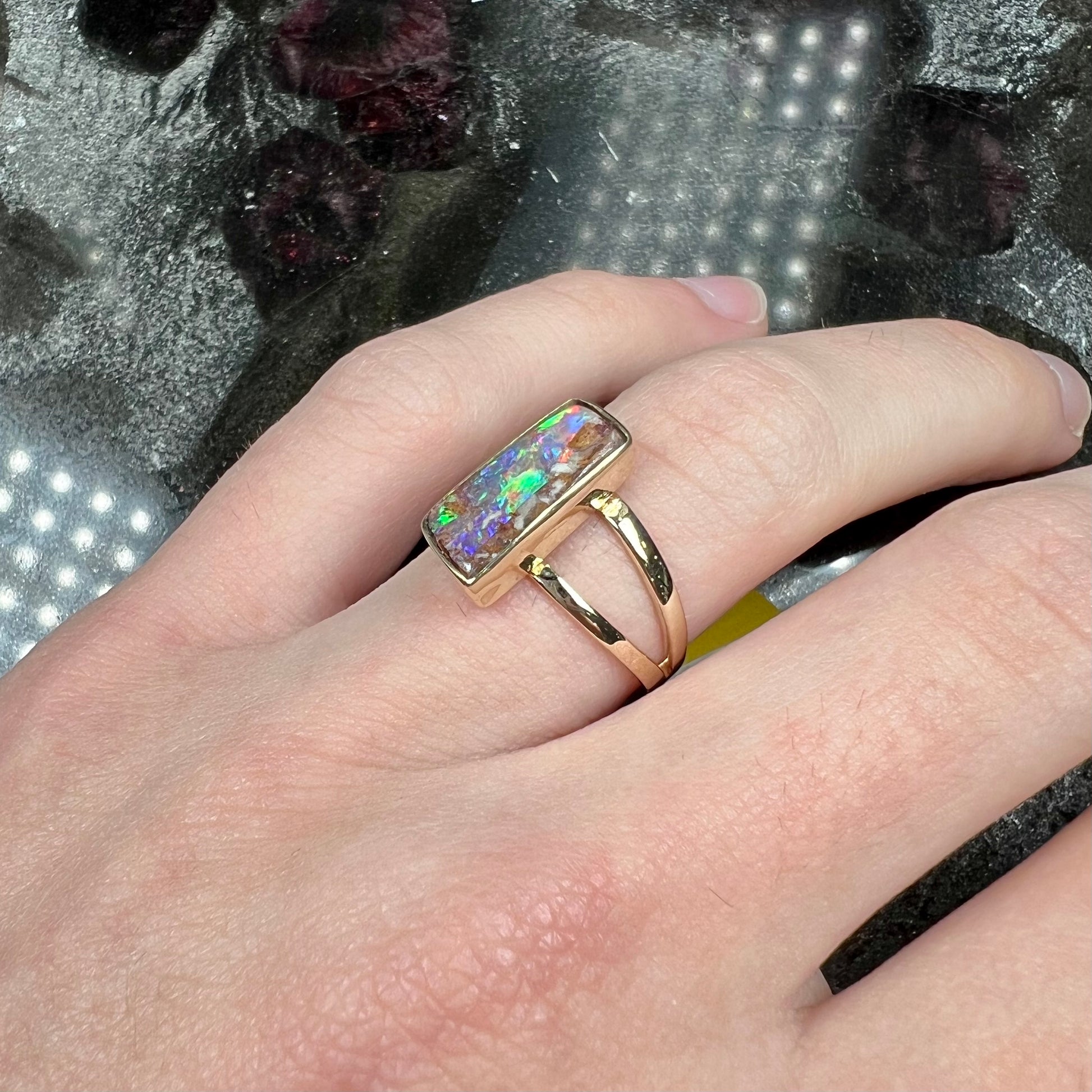 A handmade, split shank, yellow gold boulder opal solitaire ring.