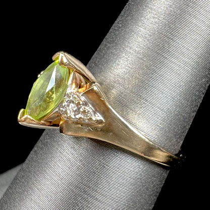 A ladies' marquise cut peridot and diamond ring in 10 karat yellow gold.