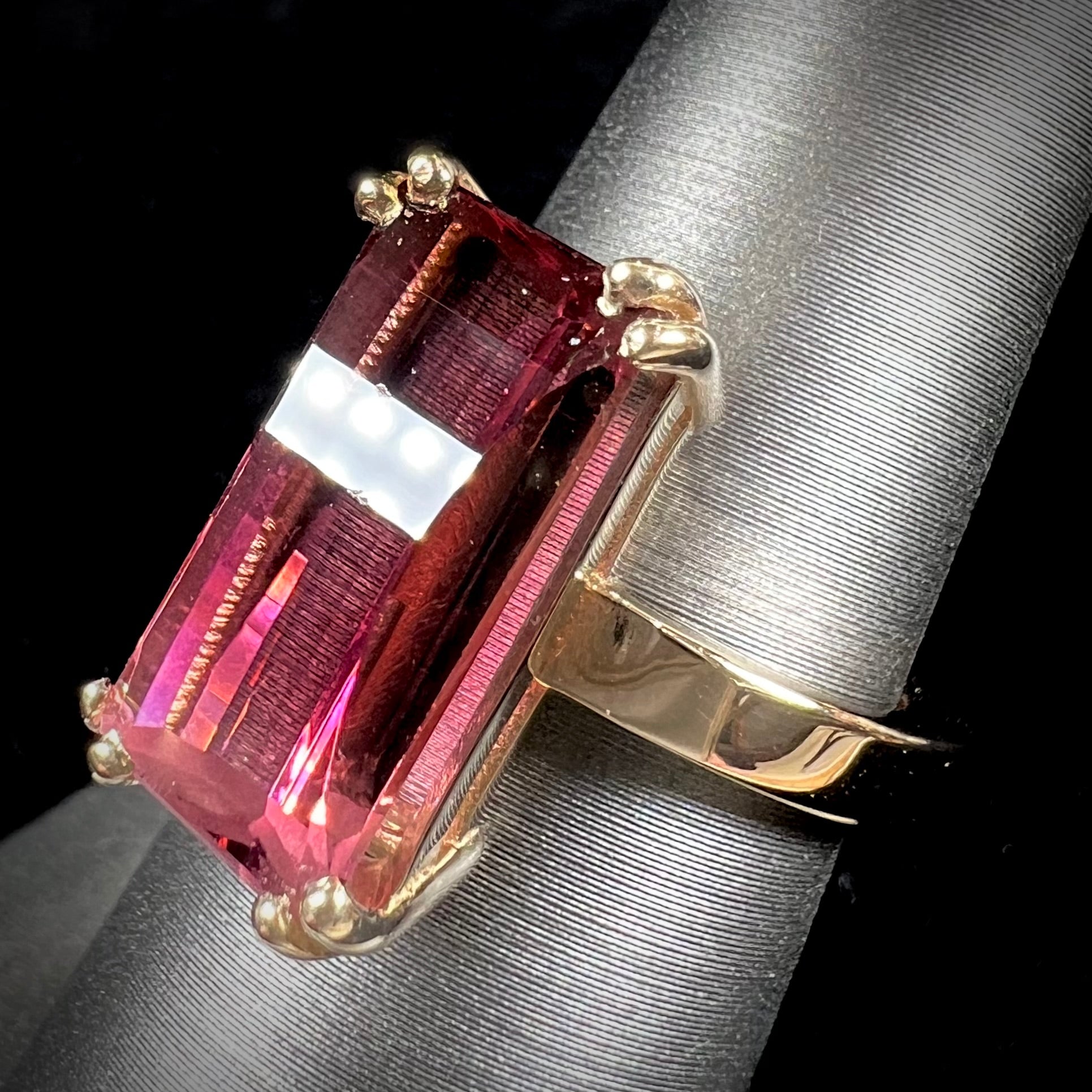 A handmade yellow gold solitaire ring set with a 7.91ct pinkish purple pixel cut tourmaline stone.