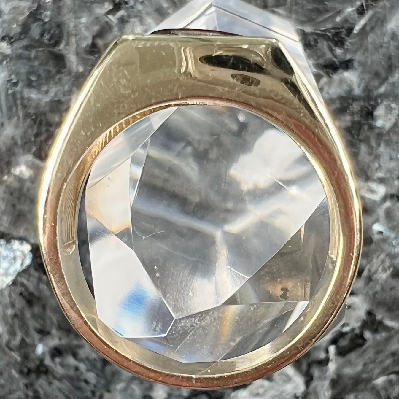 A men's yellow gold flush set fire agate solitaire ring.  The fire agate displays flashes of green, orange, and yellow.