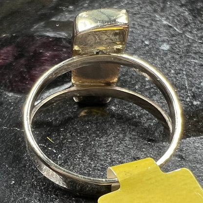 A handmade, split shank, yellow gold boulder opal solitaire ring.