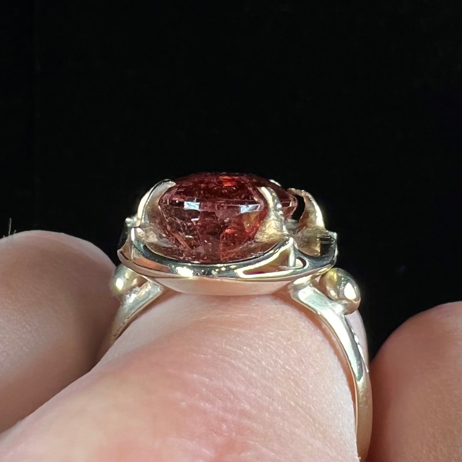 A yellow gold solitaire ring set with an oval cut, rootbeer colored tourmaline stone.
