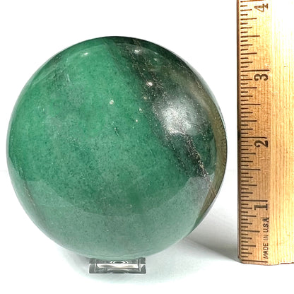 A stone sphere carved from natural green aventurine quartz with containing mica inclusions.
