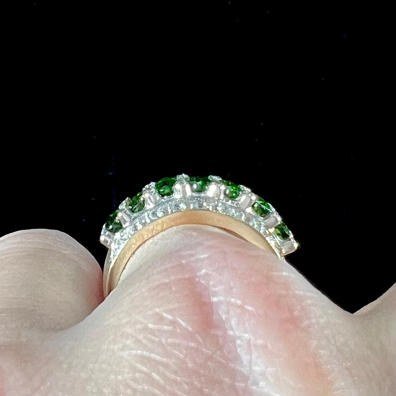A ladies' two-tone white and yellow gold ring set withseven oval cut chrome diopside stones and cubic zirconia accents.