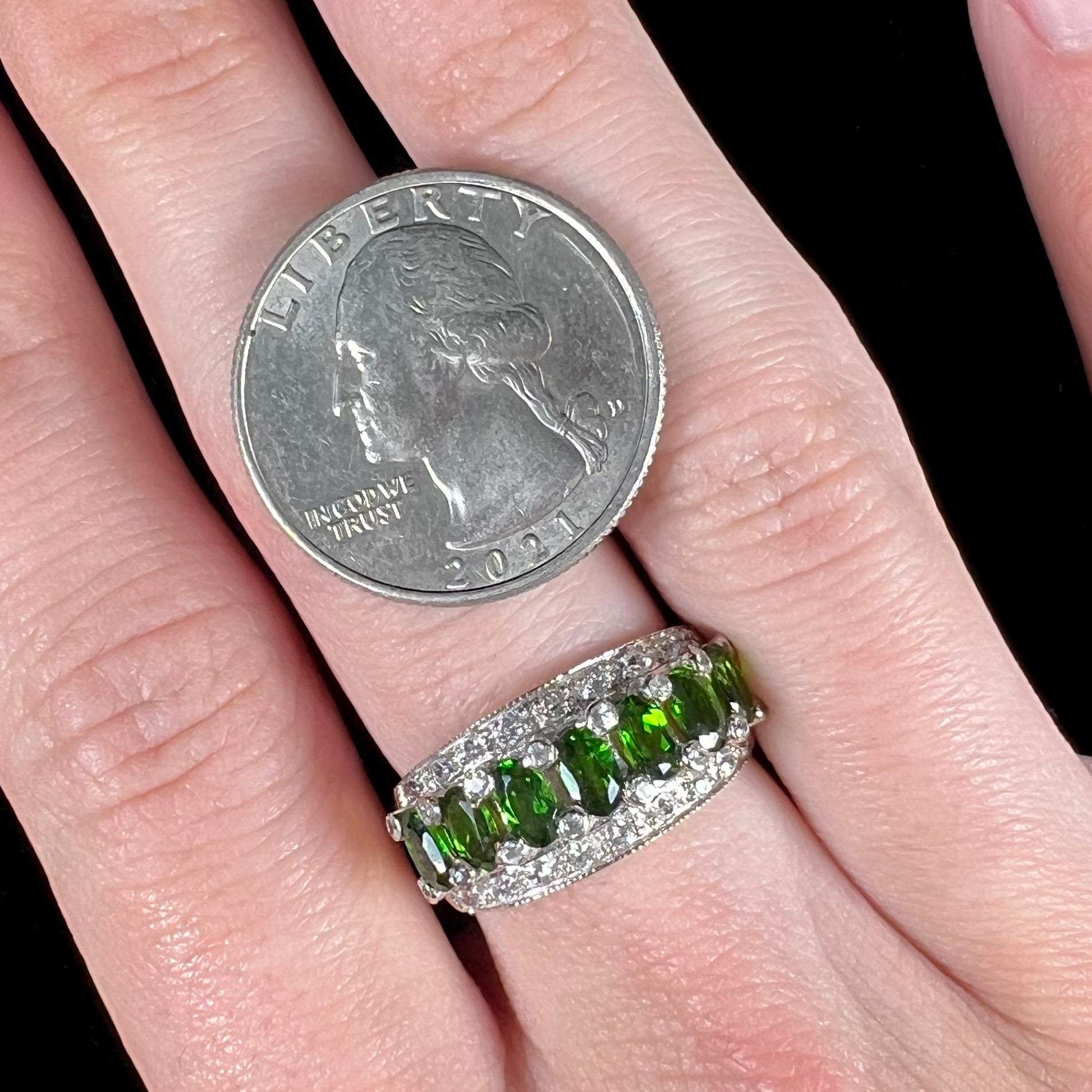 A ladies' two-tone white and yellow gold ring set withseven oval cut chrome diopside stones and cubic zirconia accents.