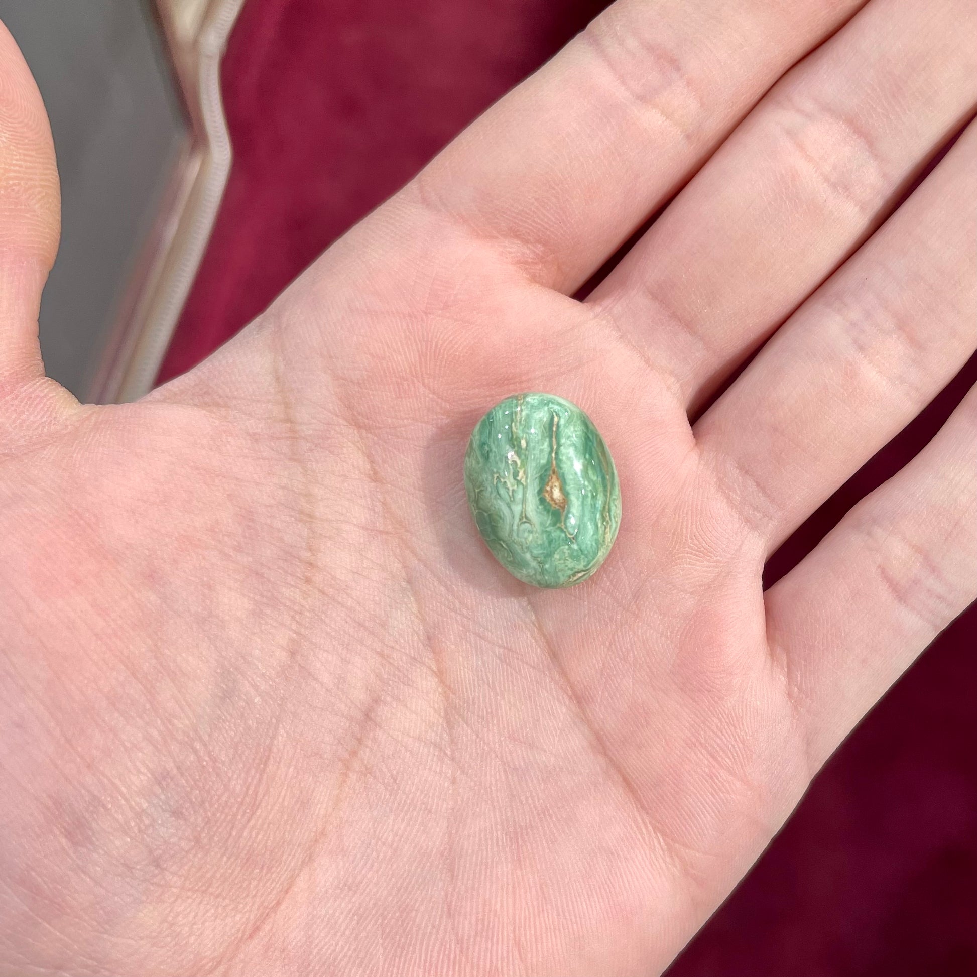 A loose, green oval cabochon cut turquoise stone from the Royston Mining District in Nevada.  Green color marbles around a light brown eye.
