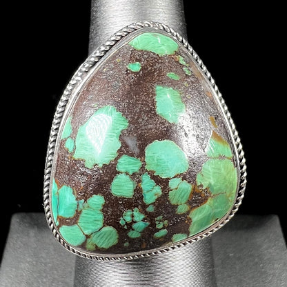 A sterling silver ring bezel set with a green spotted turquoise stone from Carico Lake, Nevada.