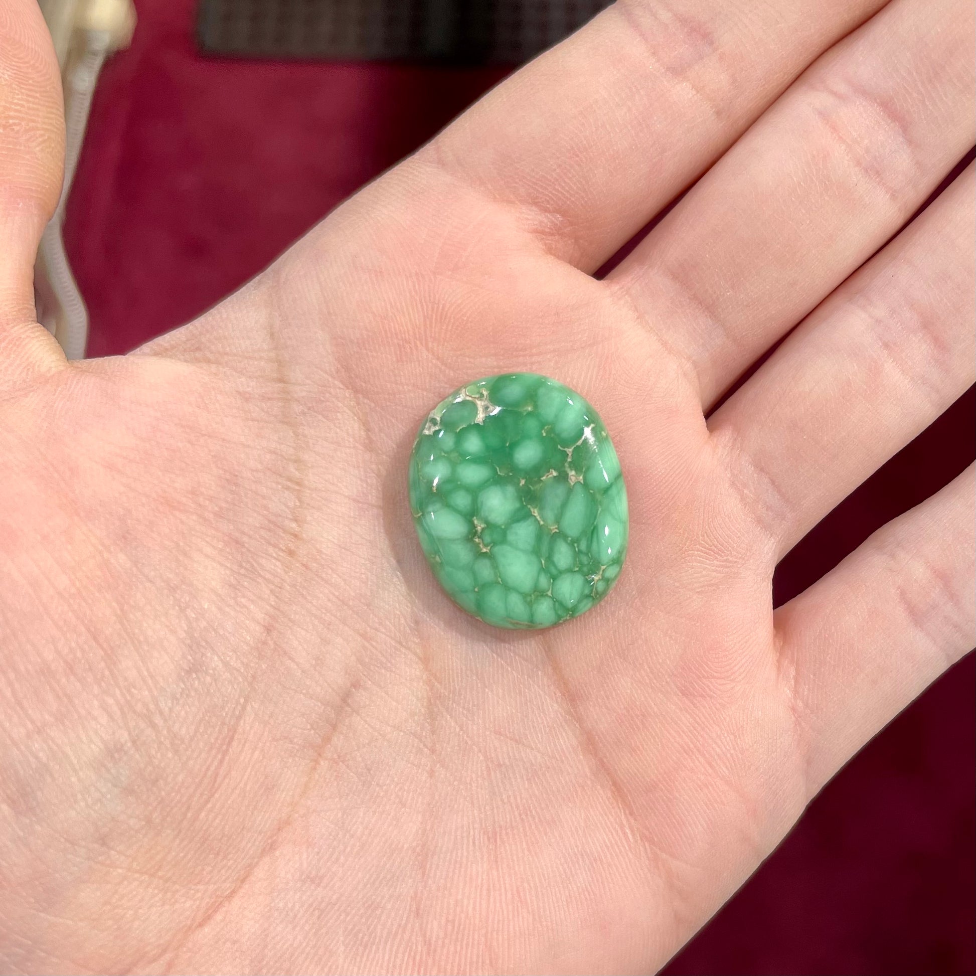 A loose, oval cabochon cut variscite stone from Utah, USA.