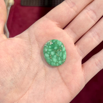 A loose, oval cabochon cut variscite stone from Utah, USA.
