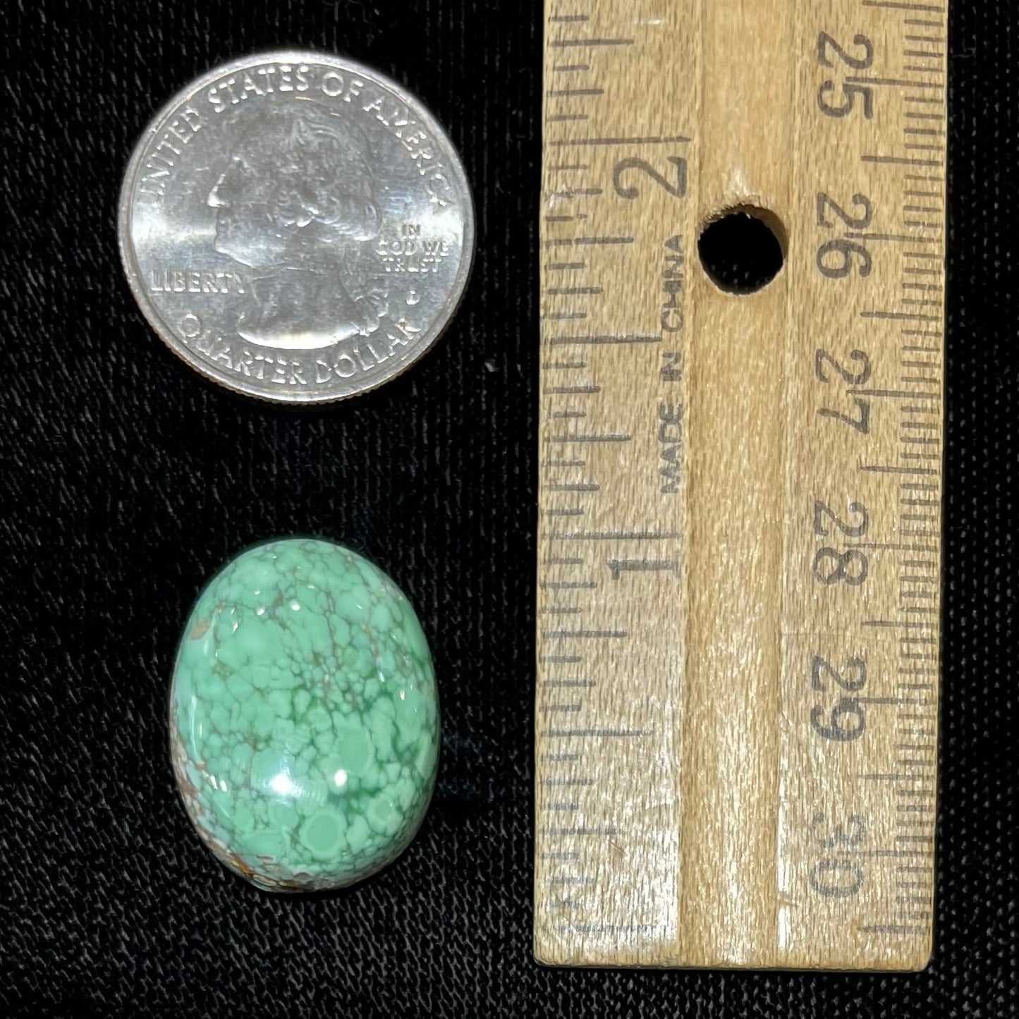 An oval cabochon cut green Variscite stone from Utah, USA.