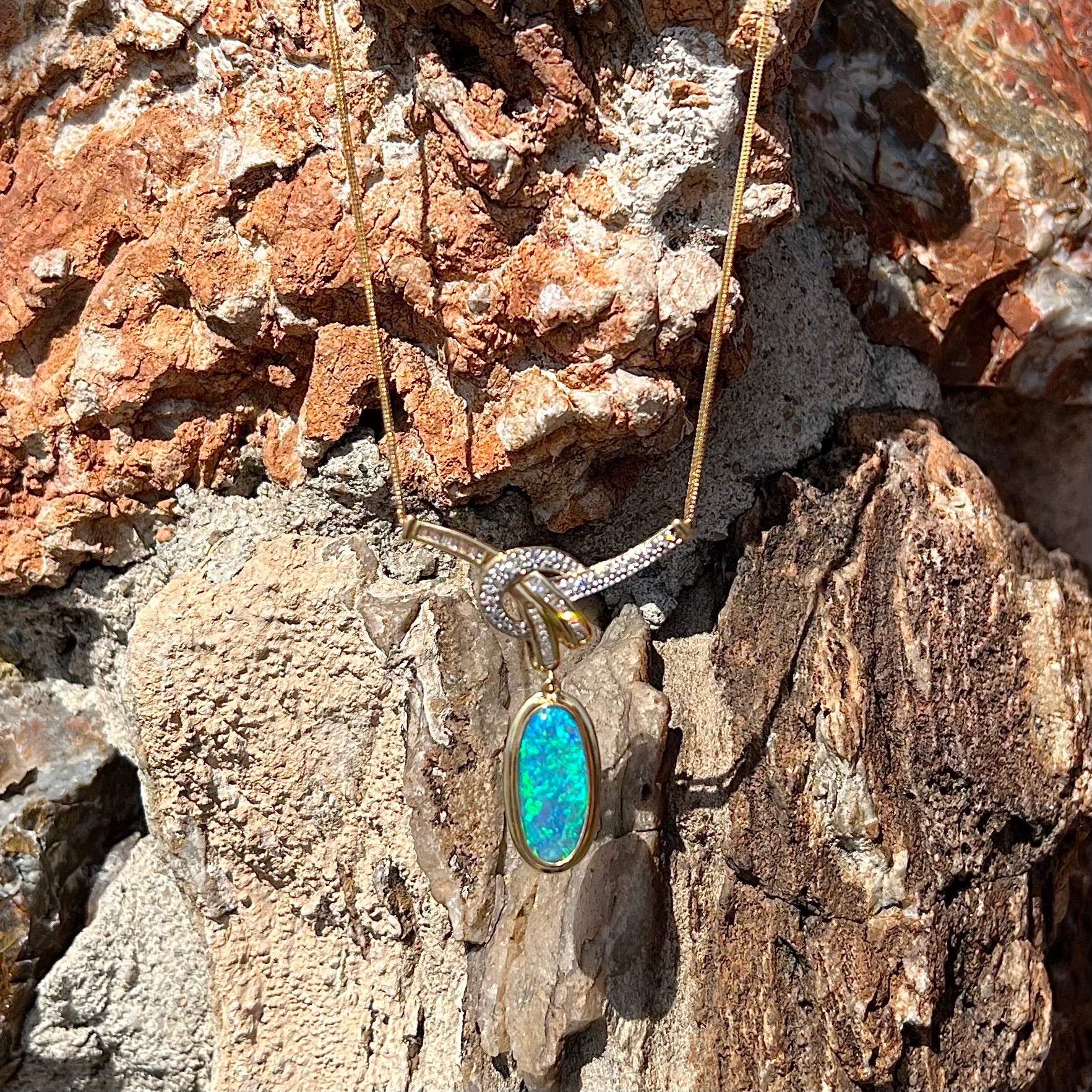 A gold black opal and diamond necklace.  There are round, princess cut, and baguette cut diamonds.