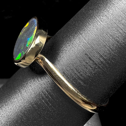 A ladies' yellow gold black opal solitaire ring from Lightning Ridge, Australia.