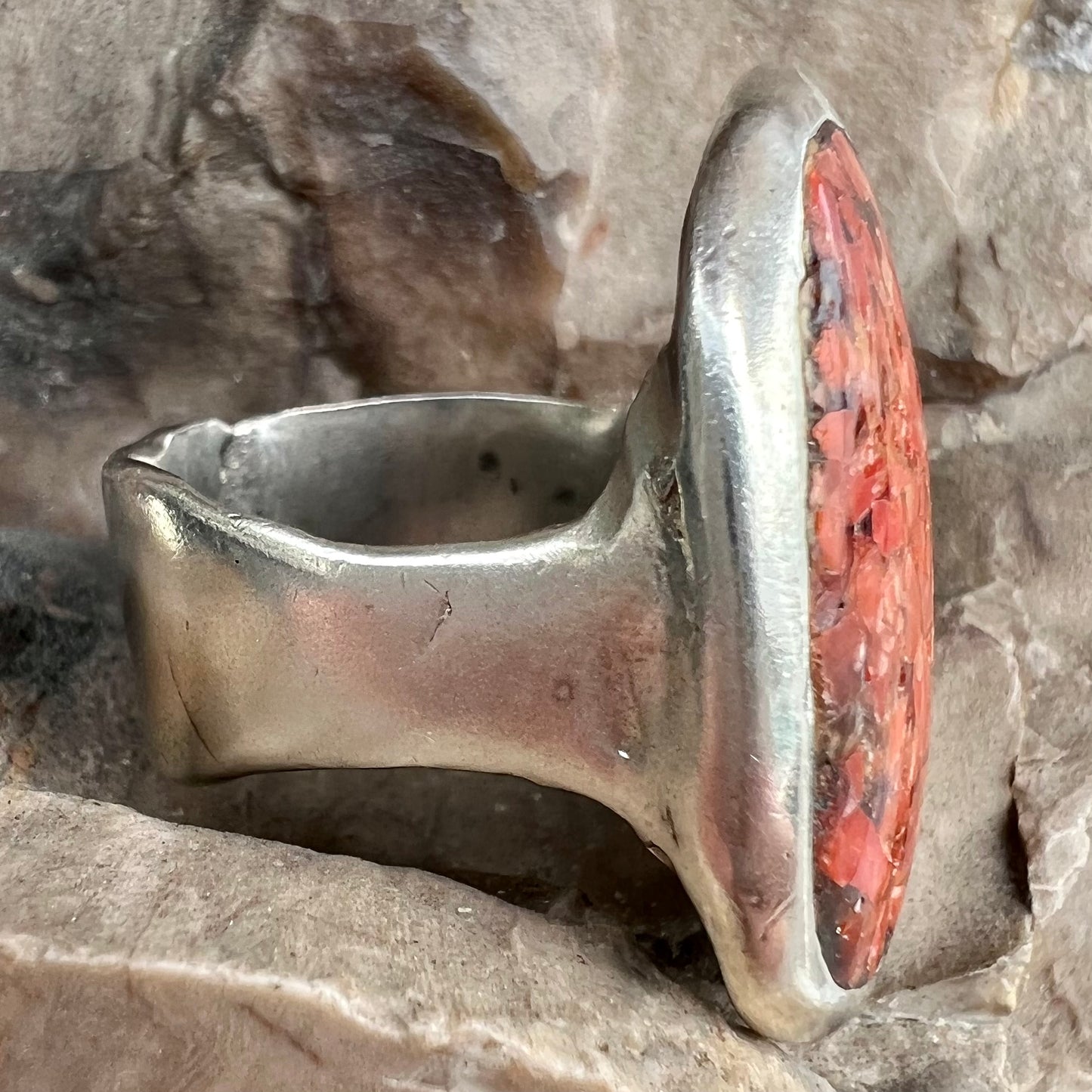 A rustic style, handmade silver men's ring set with crushed red coral.