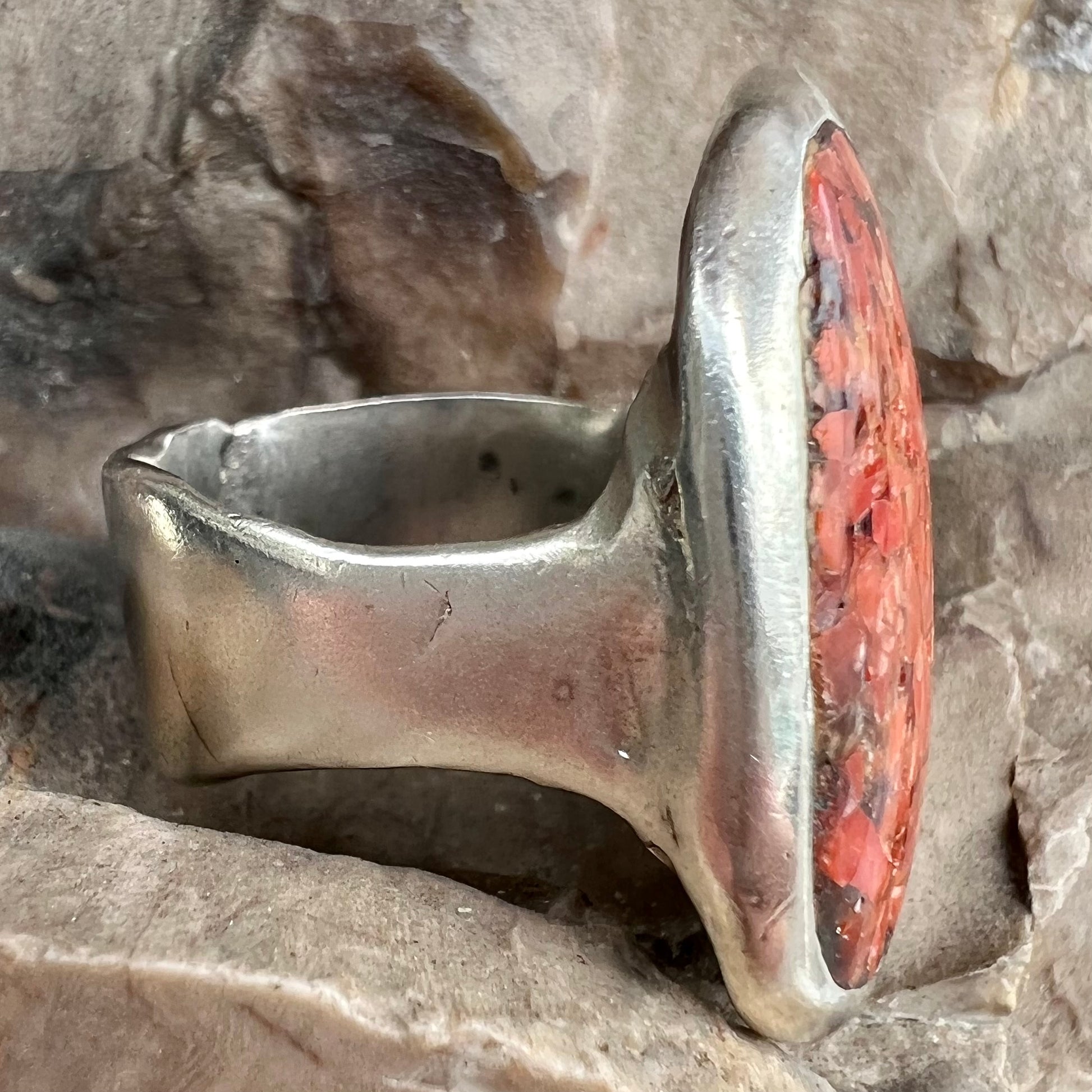 A rustic style, handmade silver men's ring set with crushed red coral.