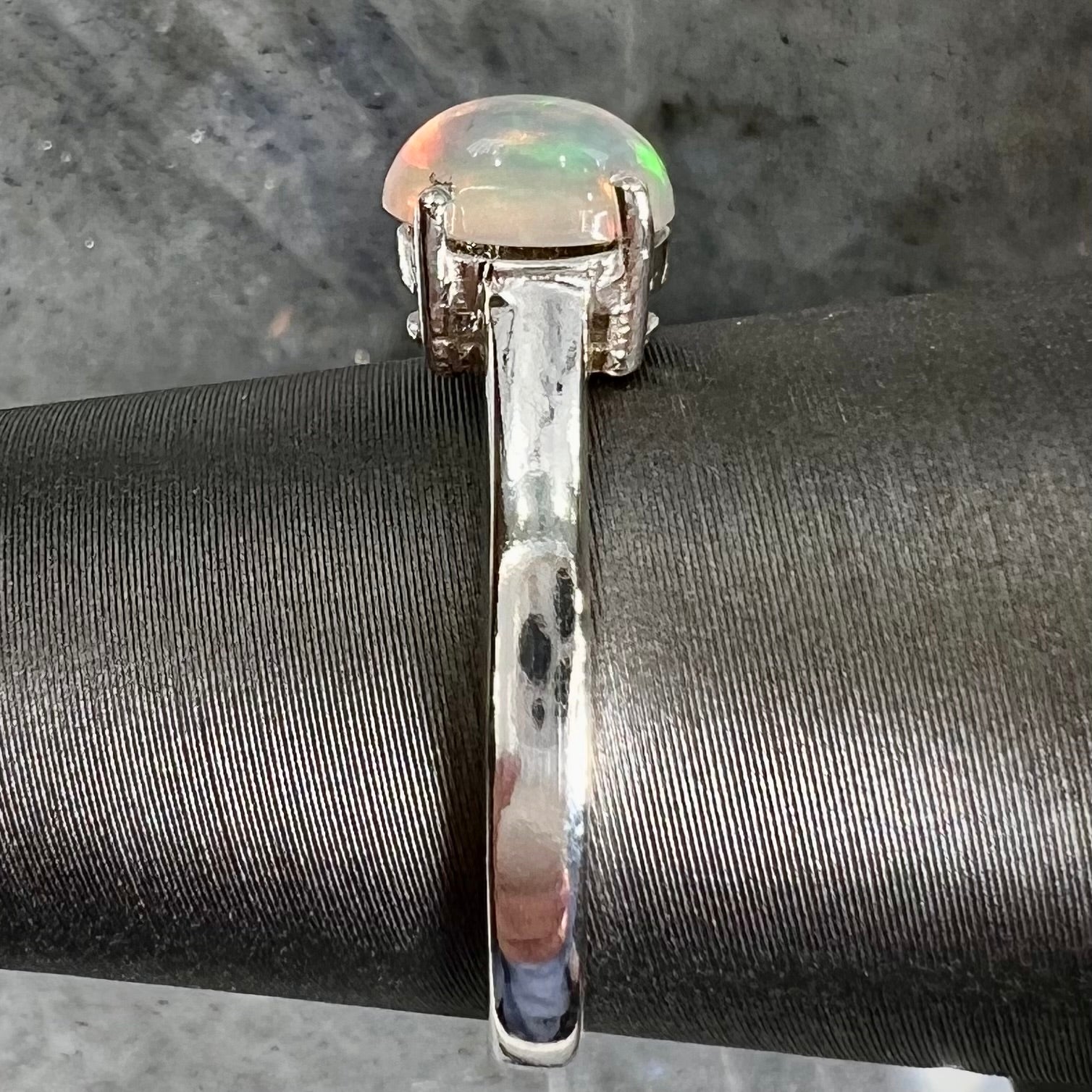 A silver, prong set, oval cabochon cut Ethiopian opal solitaire ring.