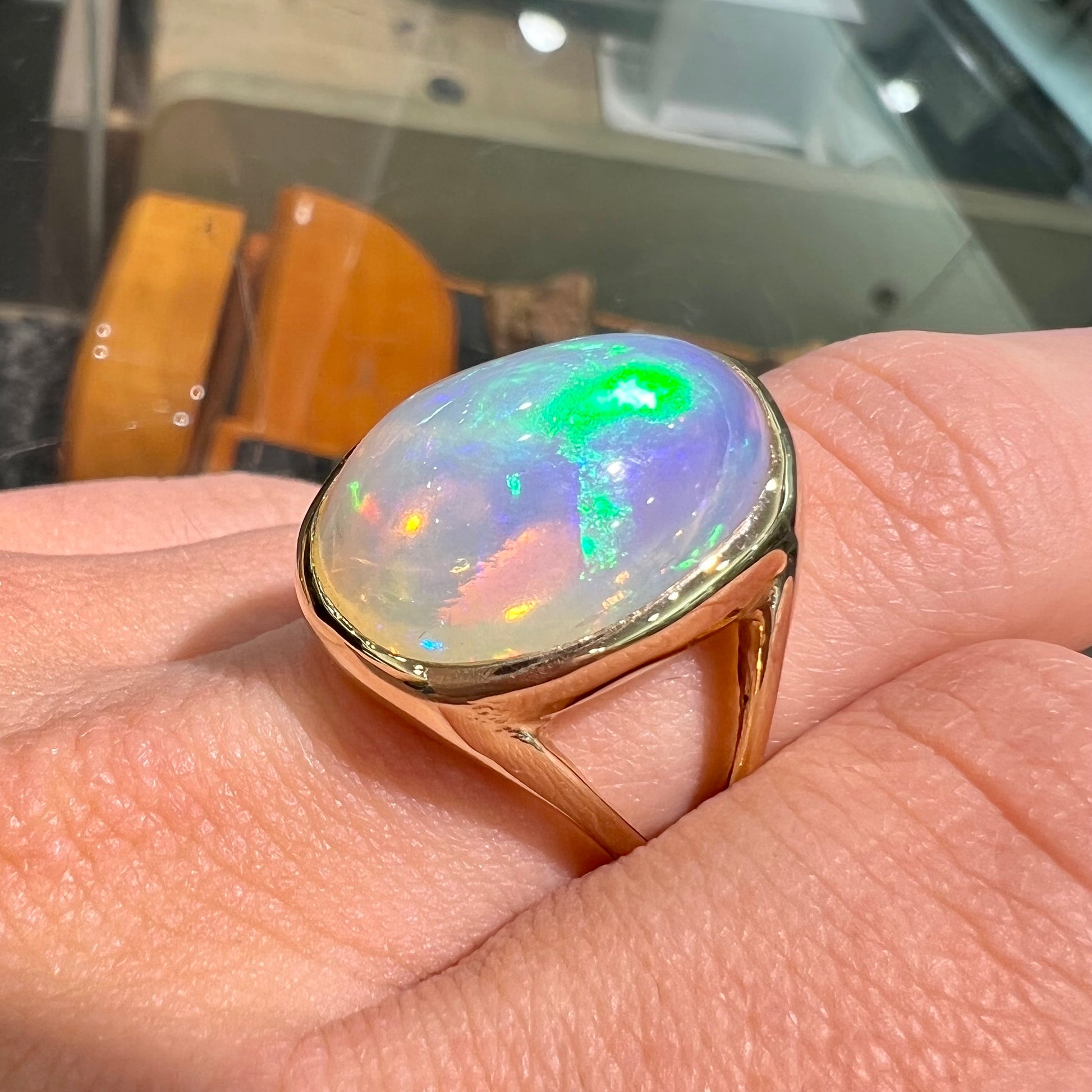 A gold split shank solitaire ring set with an oval cabochon cut 16.83 carat Ethiopian jelly fire opal.