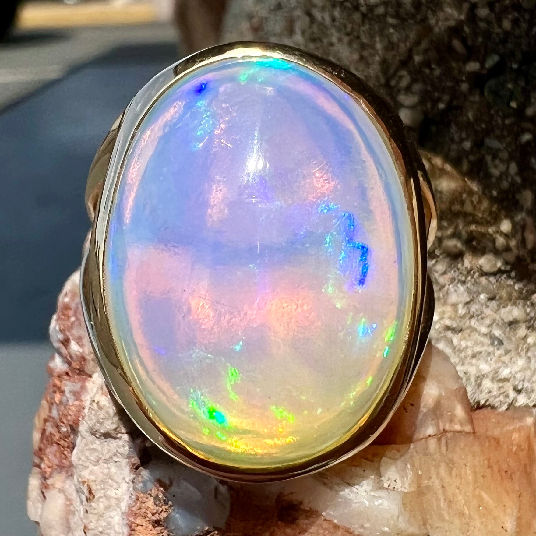 A gold split shank solitaire ring set with an oval cabochon cut 16.83 carat Ethiopian jelly fire opal.
