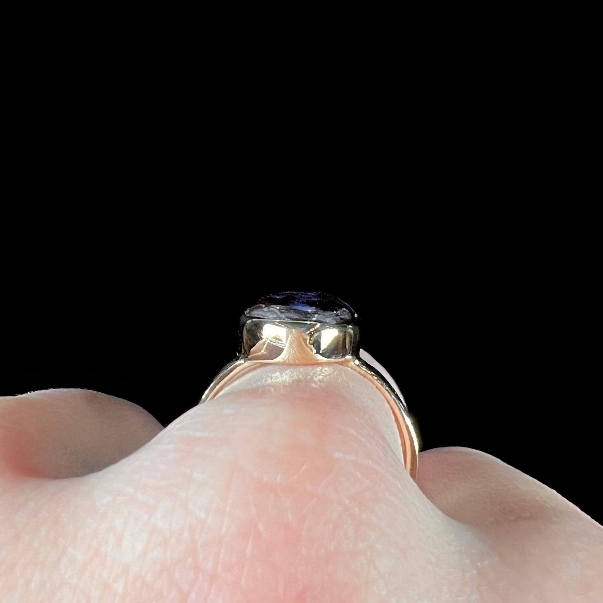 A handmade ladies' yellow gold boulder opal ring.  The opal is a natural purple Yowah nut boulder opal.
