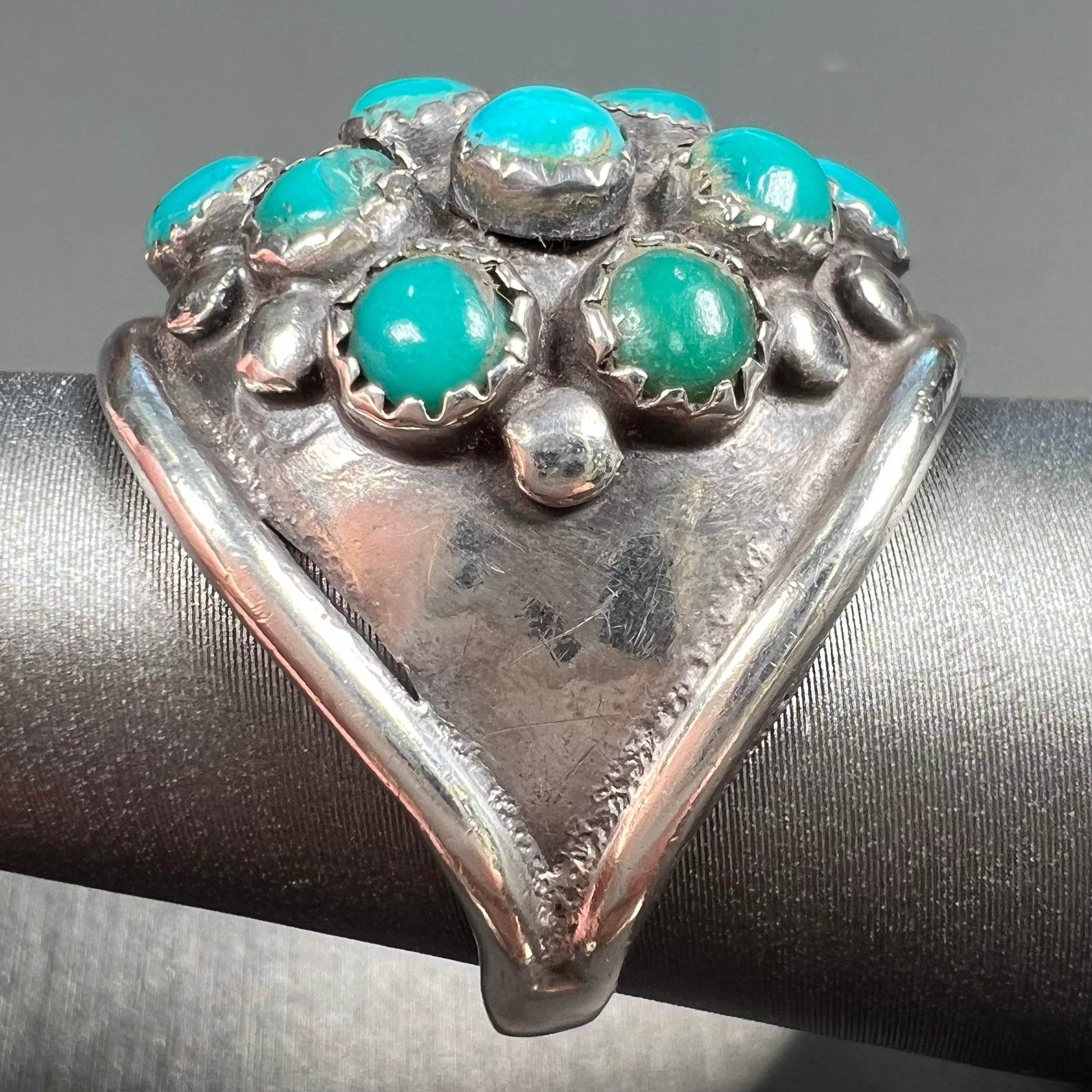 A handmade, unisex Hopi silver ring set with 14 round turquoise cabochons.