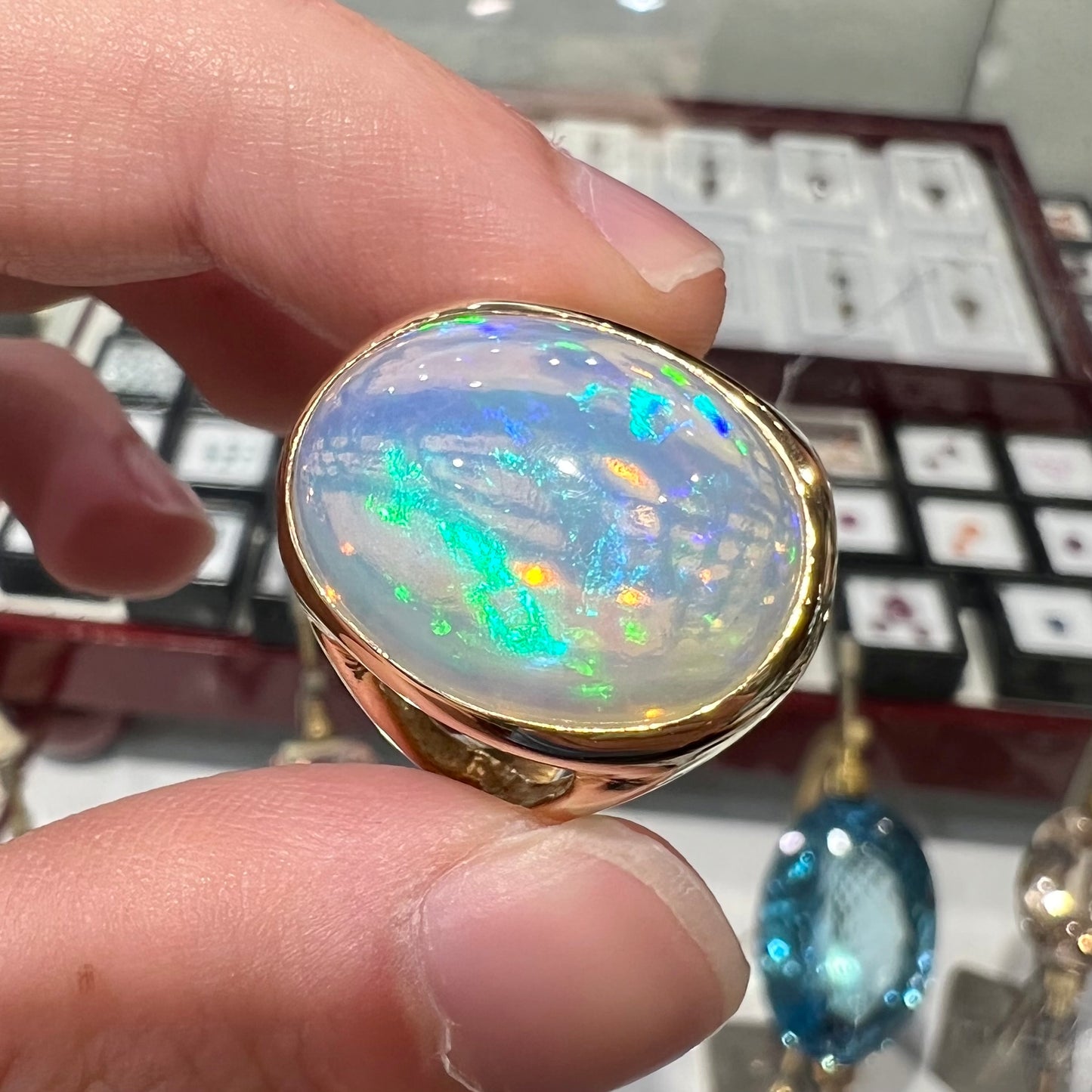 A gold split shank solitaire ring set with an oval cabochon cut 16.83 carat Ethiopian jelly fire opal.