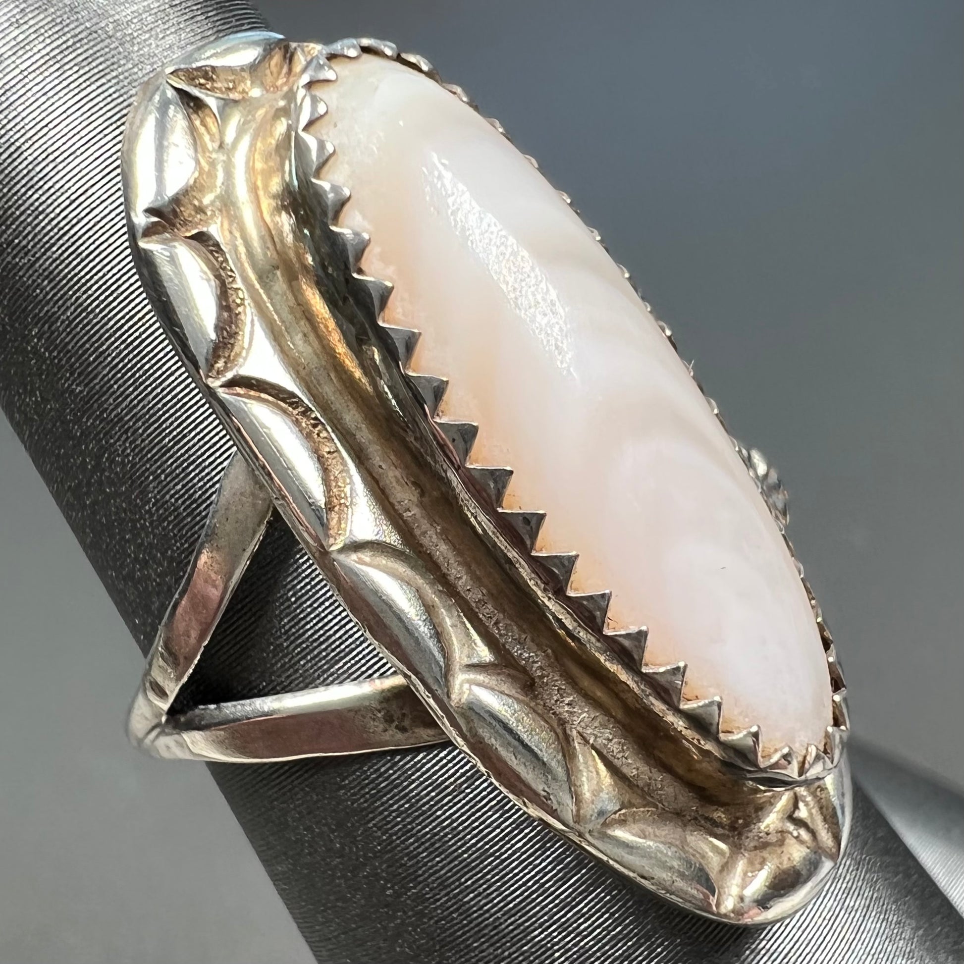 A Southwest style silver ring set with a faint pink mother of pearl stone.