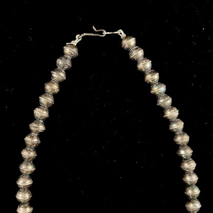 A silver Navajo style unisex squash blossom necklace set with oval cut Sleeping Beauty turquoise stones.