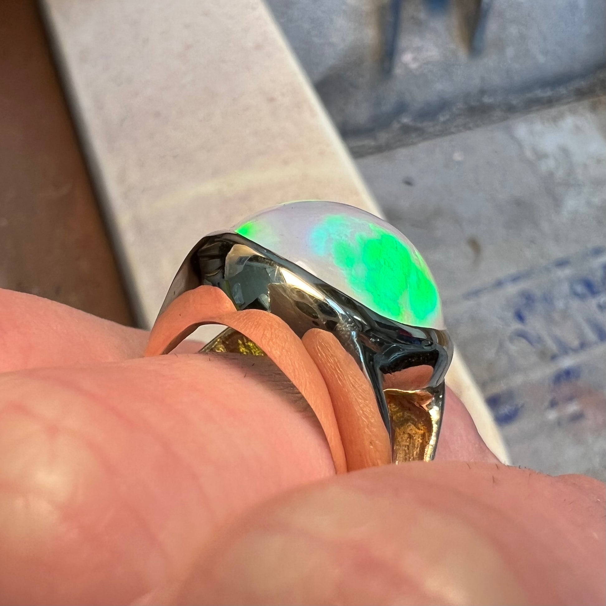 A gold split shank solitaire ring set with an oval cabochon cut 16.83 carat Ethiopian jelly fire opal.