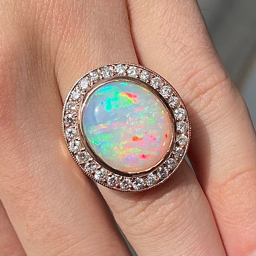 A large, Australian white crystal opal set in a rose gold and diamond halo ring.