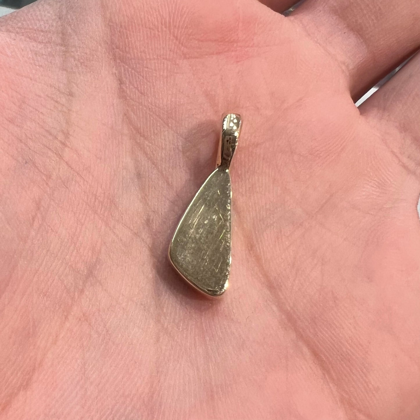 A bright green and red boulder opal bezel pendant in solid yellow gold.