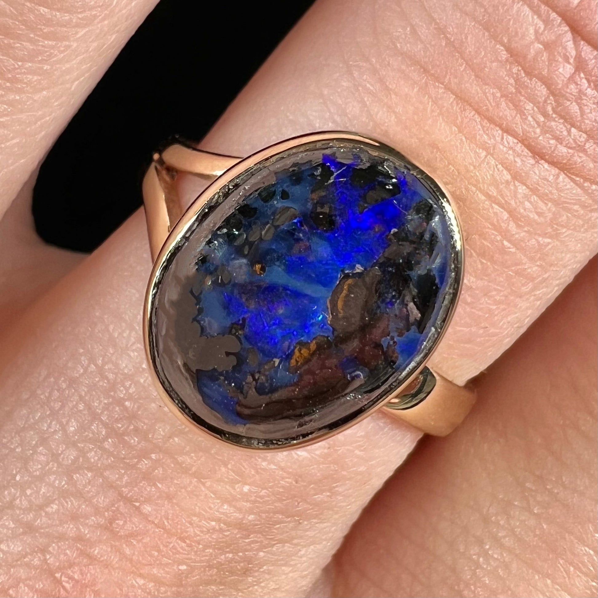 A handmade ladies' yellow gold boulder opal ring.  The opal is a natural purple Yowah nut boulder opal.