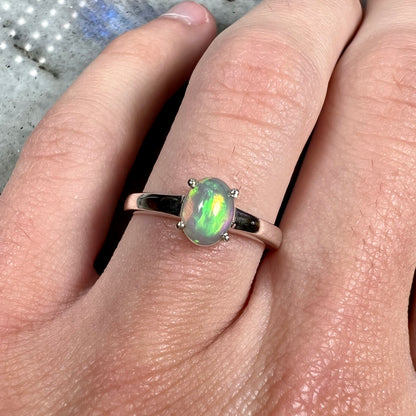 A silver, prong set, oval cabochon cut Ethiopian opal solitaire ring.