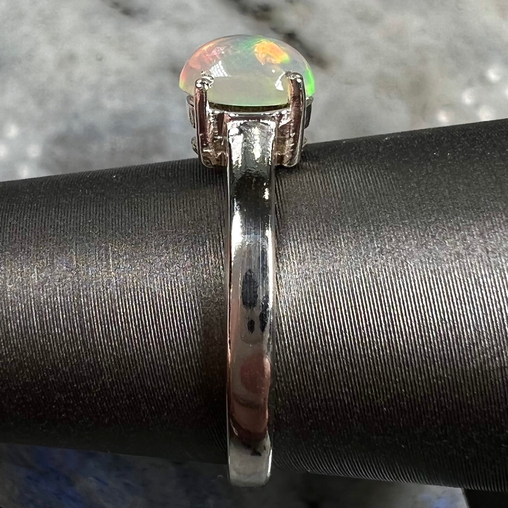 A silver, prong set, oval cabochon cut Ethiopian opal solitaire ring.