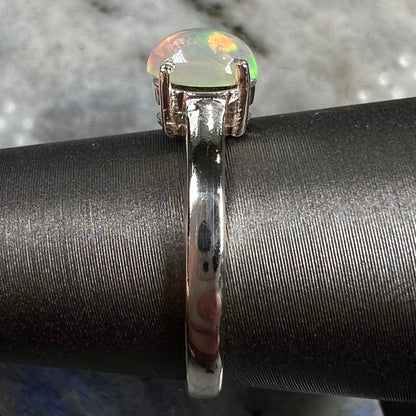A silver, prong set, oval cabochon cut Ethiopian opal solitaire ring.