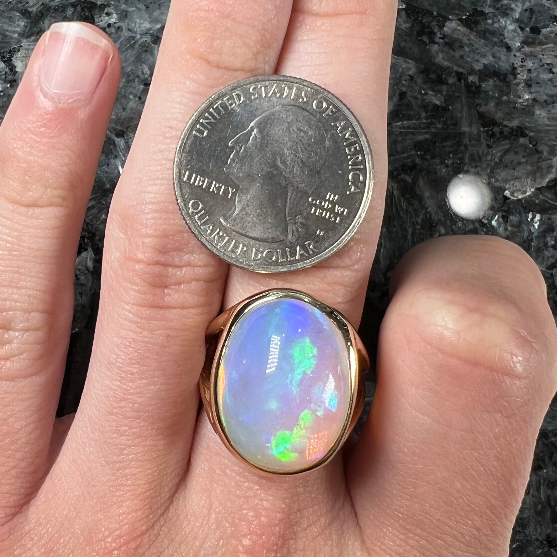 A gold split shank solitaire ring set with an oval cabochon cut 16.83 carat Ethiopian jelly fire opal.