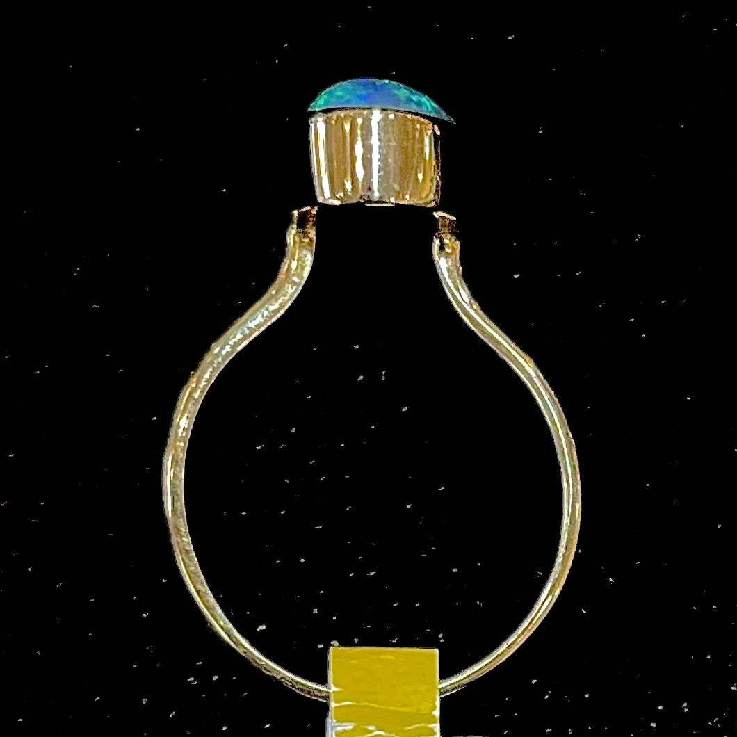 A simple yellow gold solitaire ring with a bezel set Lightning Ridge black crystal opal from Australia.