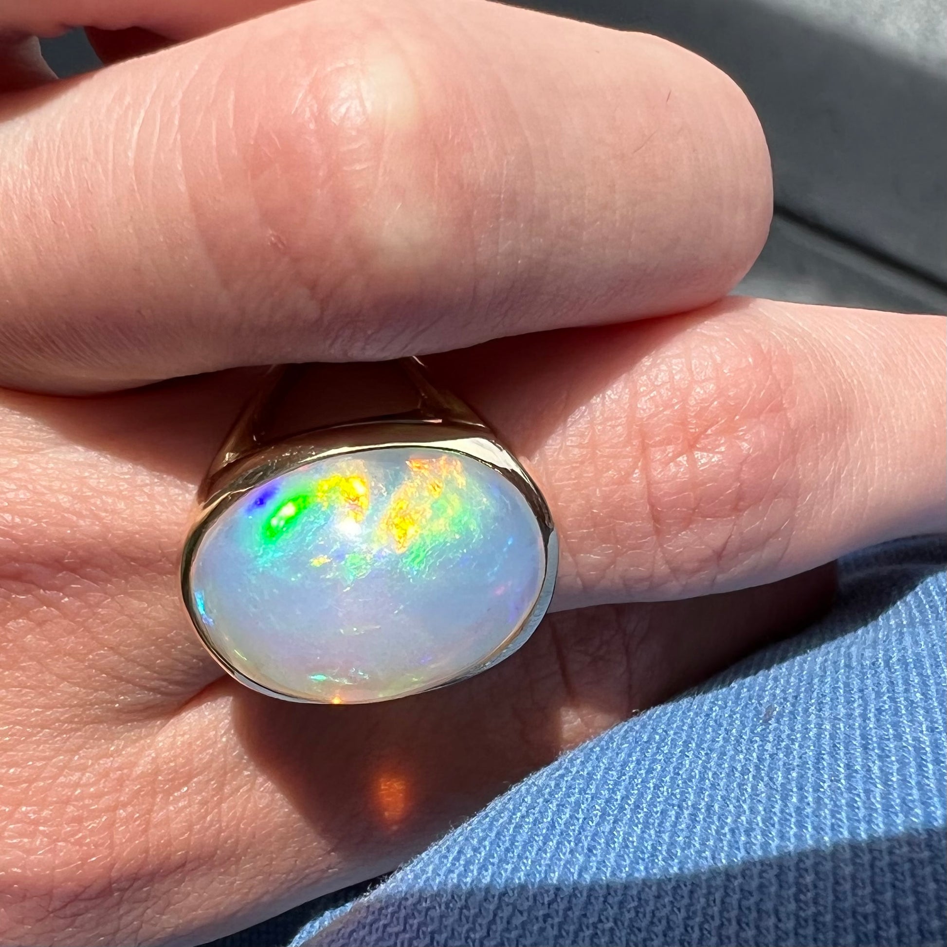 A gold split shank solitaire ring set with an oval cabochon cut 16.83 carat Ethiopian jelly fire opal.